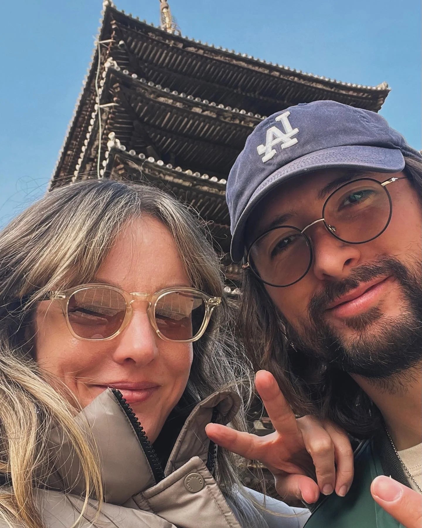 Beto's Better Butter co-founders, Beto and Mia, posing for a selfie with a traditional Japanese temple in the background