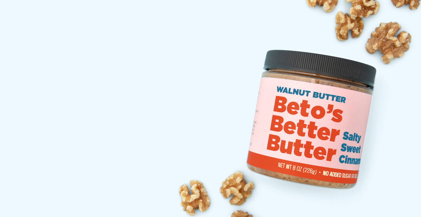 Jar of Beto's Better Butter with walnuts on a blue background