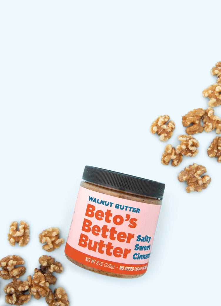 Jar of Beto's Better Butter with walnuts on a blue background