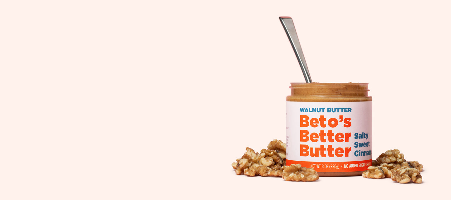 Jar of Beto's Butter with a spoon and walnuts on a white background
